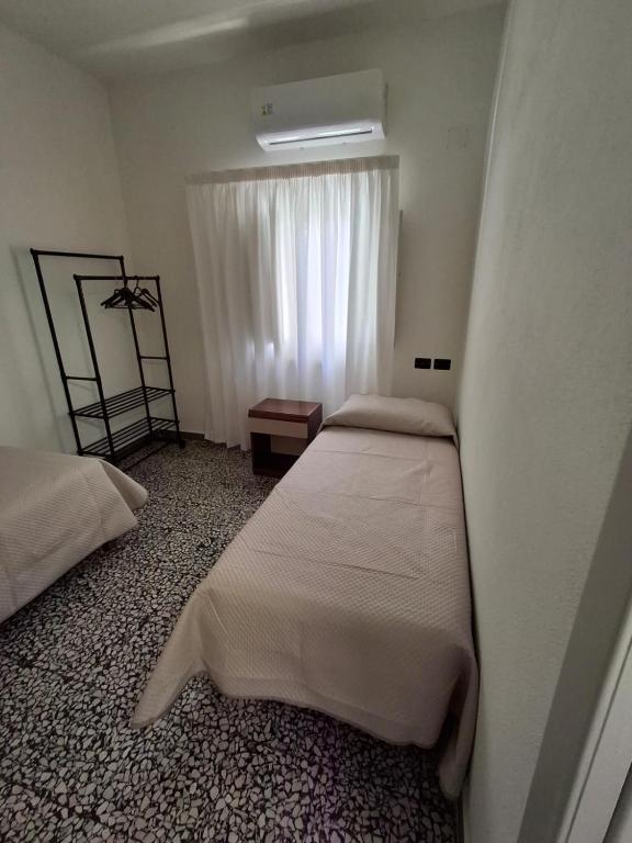 sypialnia z dwoma łóżkami i oknem w obiekcie Appartamento Olbia w mieście Olbia