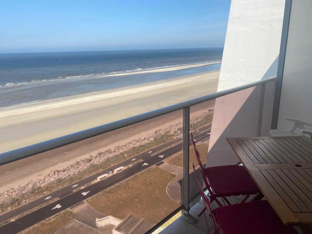 un balcon avec une table et des chaises et l'océan dans l'établissement Neptune I6 Hardelot, à Neufchâtel-Hardelot