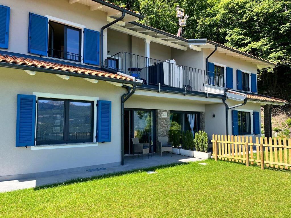 a house with blue shutters and a yard at Villa Serenissima in Someraro