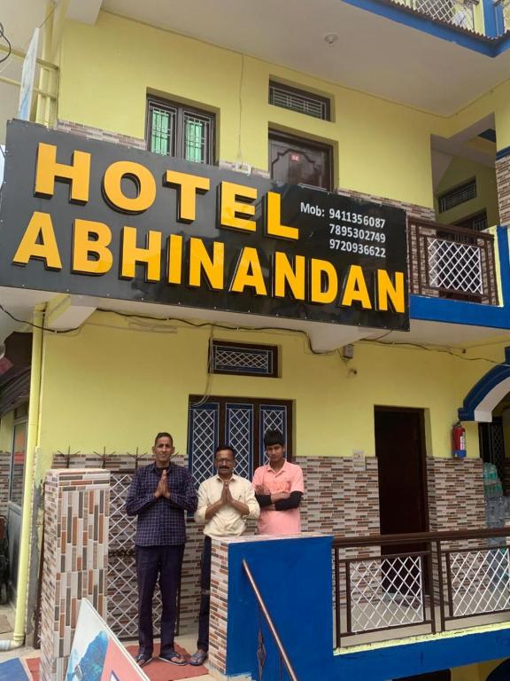 three men standing in front of a hotel ahtarandan sign at Hotel Abhinandan in Phata