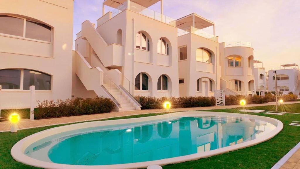 a villa with a swimming pool in front of a building at Italian Experience - Brezza Costa Conero con Terrazza in Marcelli