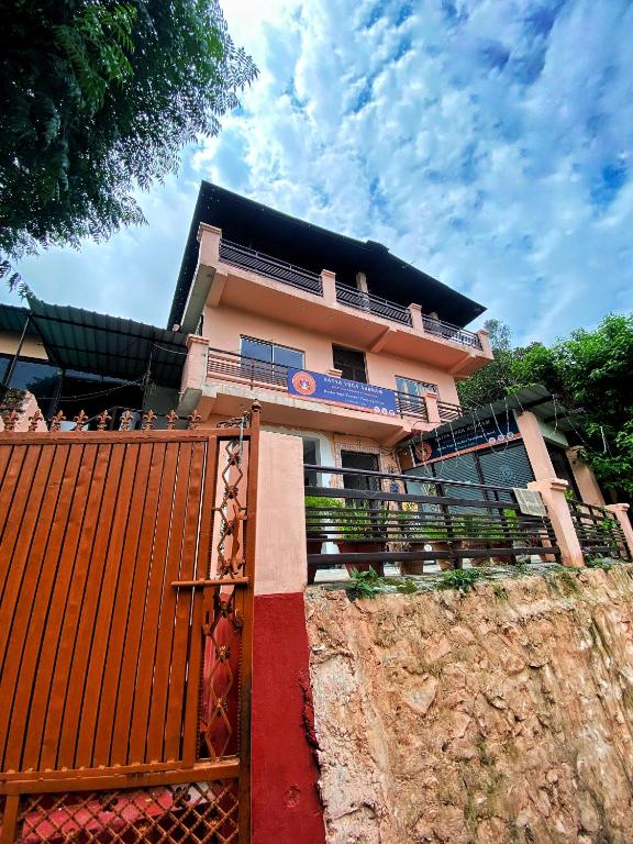 a building with a red gate in front of it at Satya Yoga Ashram Rishikesh in Narendranagar