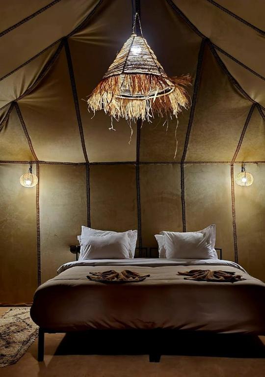 a bedroom with a bed in a tent at Yamanda luxury camp in Merzouga