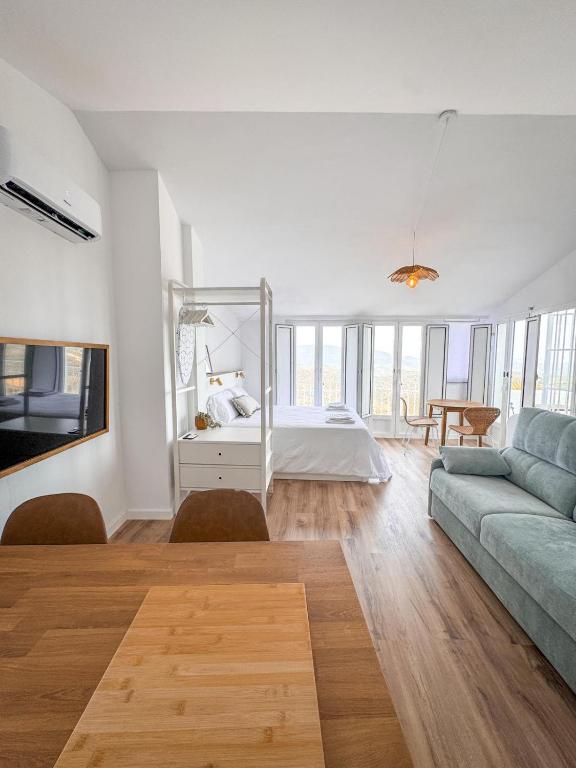 a living room with a bed and a couch at Loft Deluxe Torre del Pan in Olvera