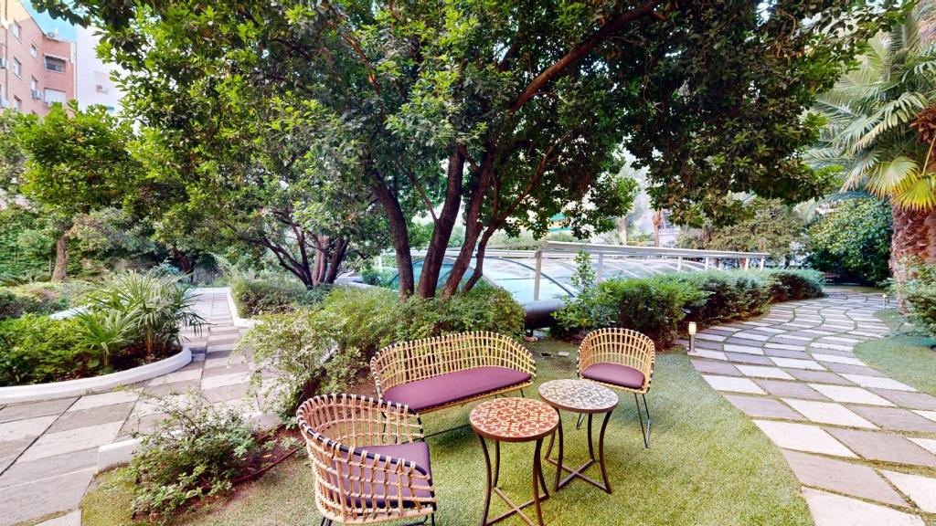 a patio with three chairs and a table with purple seats at VP Madroño in Madrid
