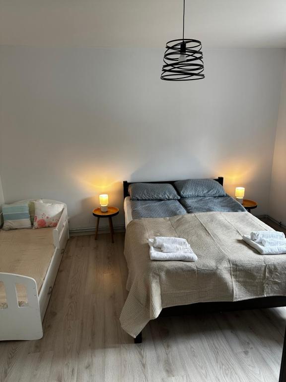 a bedroom with a bed and two tables with lamps at Apartament u Magdy in Giżycko