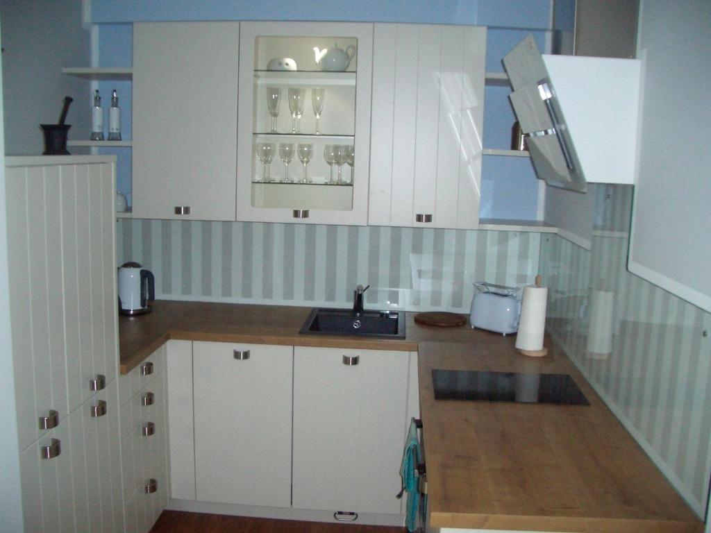 a kitchen with white cabinets and a sink at LOFT - Apartment PORT SEA SHELL Hafenspitze Quartier in Eckernförde