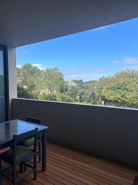 a dining room with a table and a large window at Suite Vos in Hermanus