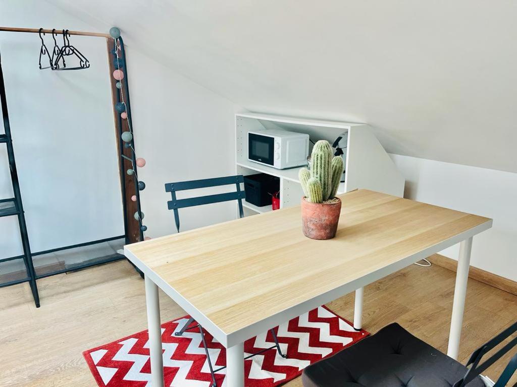 une table avec une plante assise au-dessus dans l'établissement Chavalliaud 10 studio cosy à 2 pas du centre, à Reims