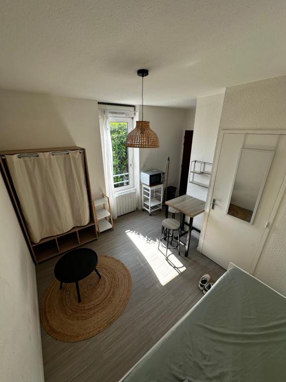 Elle offre une vue sur un salon doté d'une table et d'une fenêtre. dans l'établissement Studio paisible, à Vannes