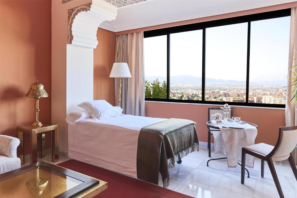 A bed or beds in a room at Alhambra Palace Hotel