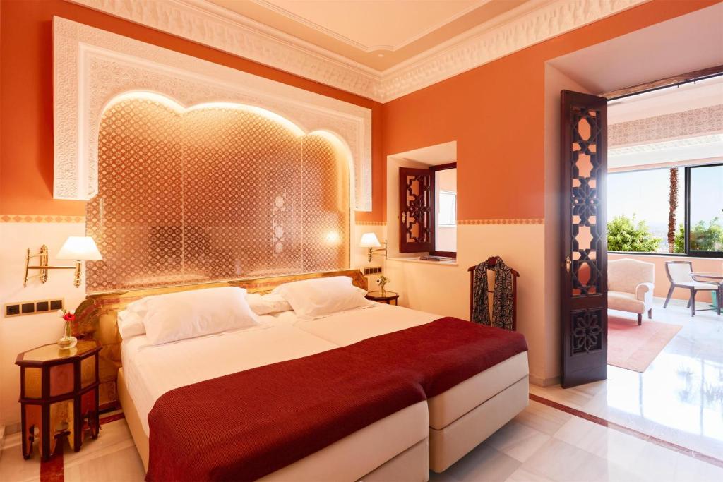 A bed or beds in a room at Alhambra Palace Hotel