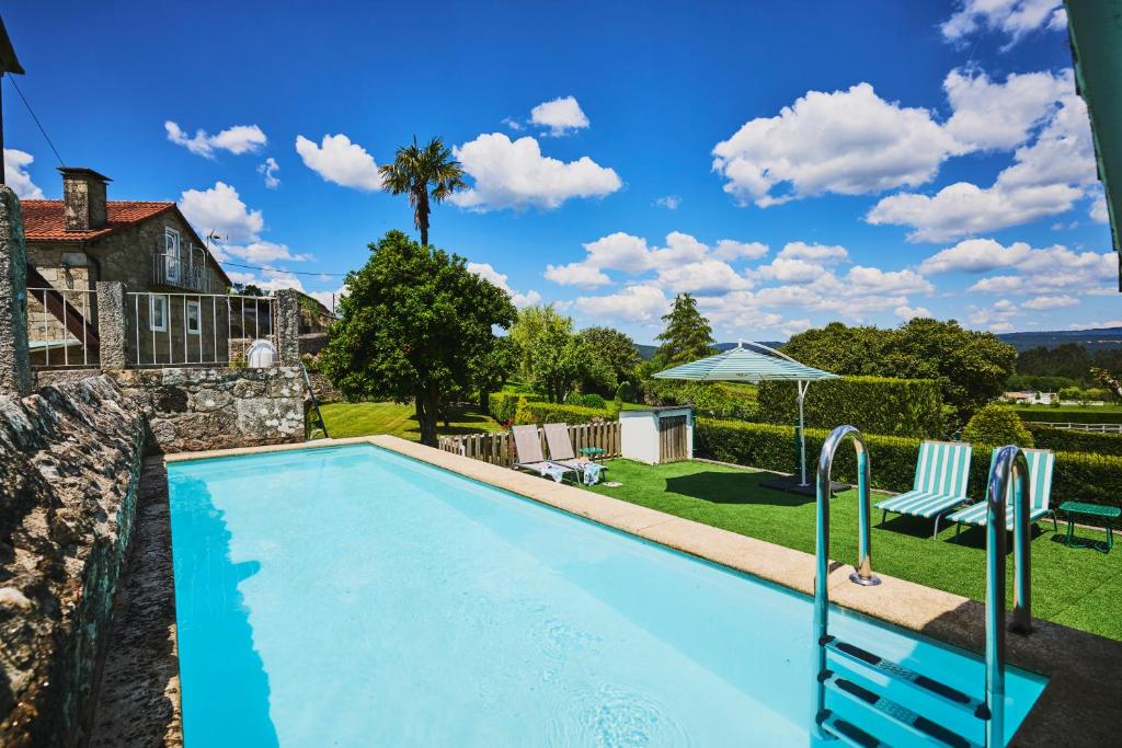 a swimming pool in the backyard of a house at La casa de los Barbazanes in Brion