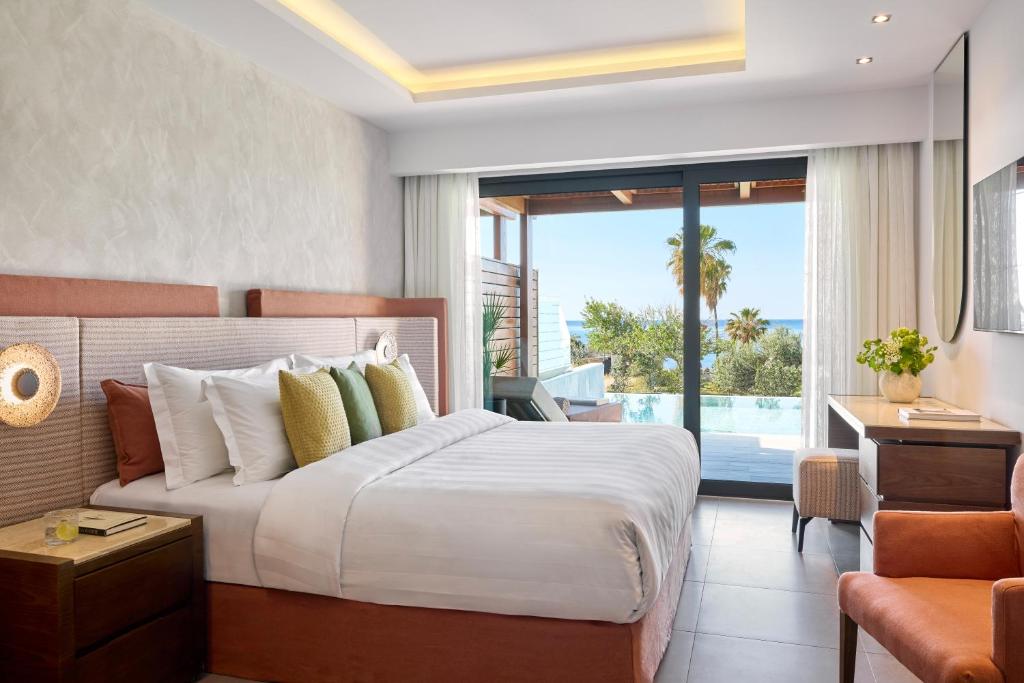 een slaapkamer met een groot bed en een balkon bij Boutique 5 Hotel & Spa - Adults Only in Kiotari