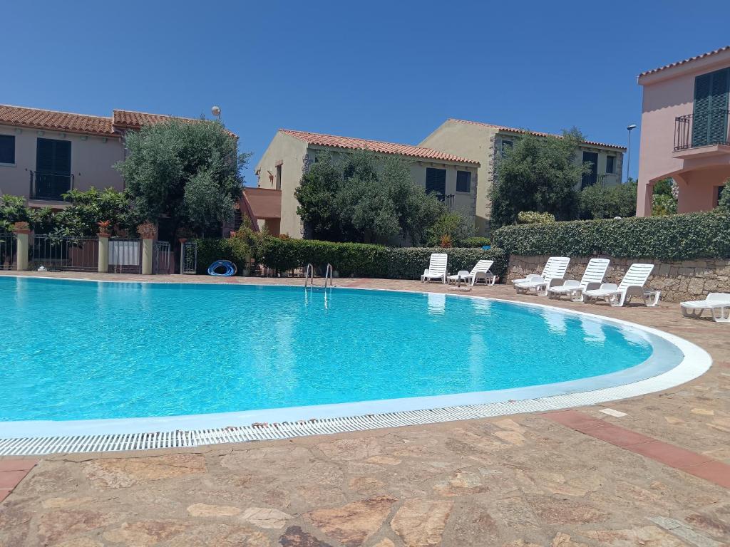 a swimming pool in a resort with lounge chairs at Domus Lavinia in Badesi