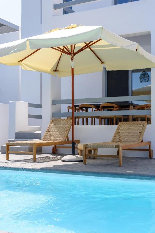a yellow umbrella and chairs next to a swimming pool at Villa Evi in Kastraki