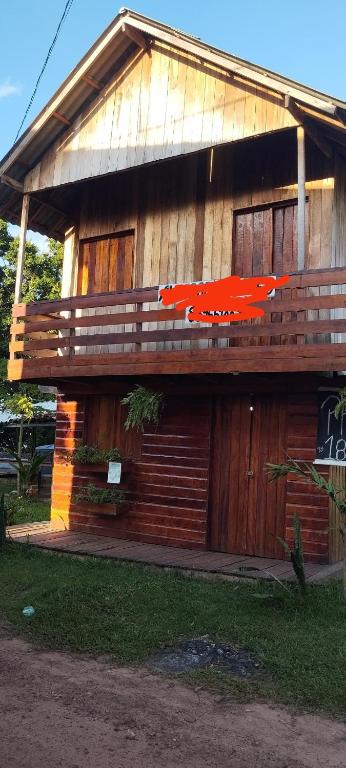 a wooden building with a red plane painted on it at Marujus cotijuba in Belém