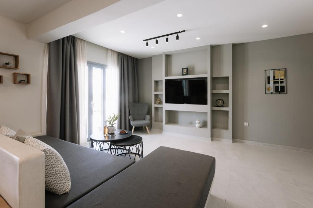 a living room with a couch and a tv at Naxos Finest Villa with Private Pool and Hot Tub at MIKRI VIGLA, Naxos in Mikri Vigla