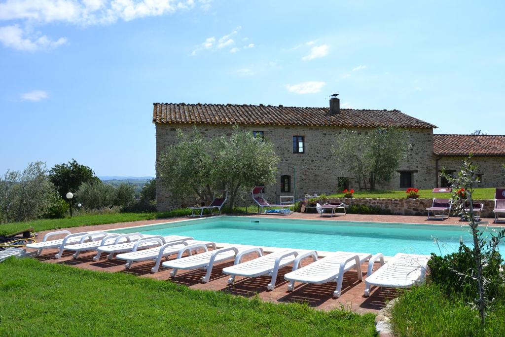 a group of lounge chairs and a swimming pool at Perugia Farmhouse in Perugia