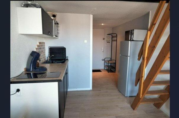 une cuisine avec un évier et un réfrigérateur dans l'établissement Le plaisir de la corniche - Saint Hilaire de Riez, à Saint-Hilaire-de-Riez