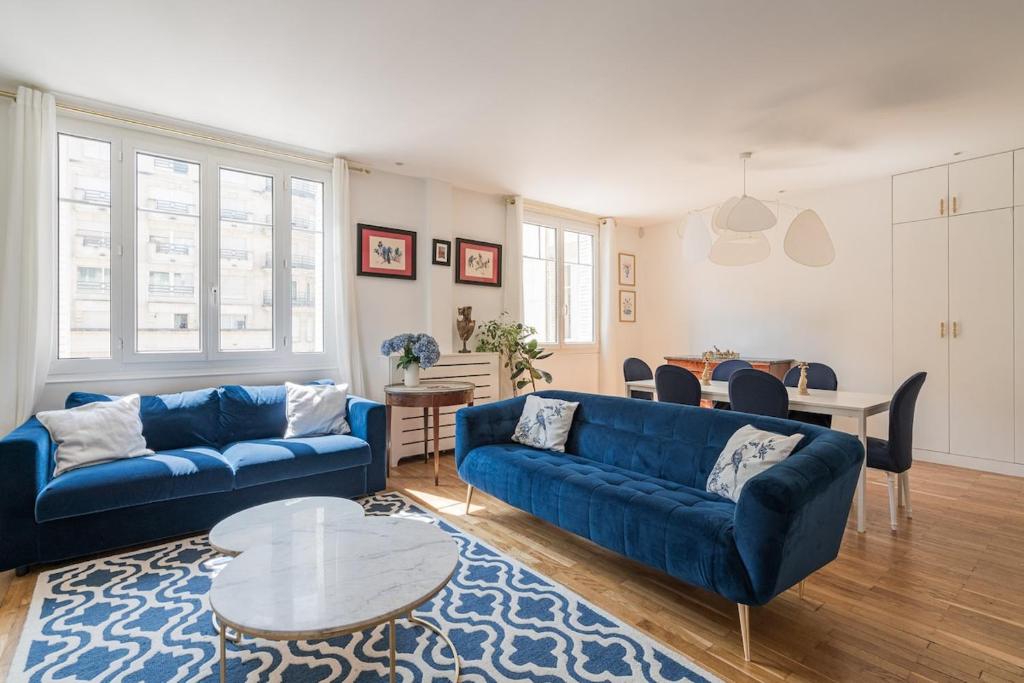 un salon avec deux canapés bleus et une table dans l'établissement Veeve - Ethereal Light, à Paris