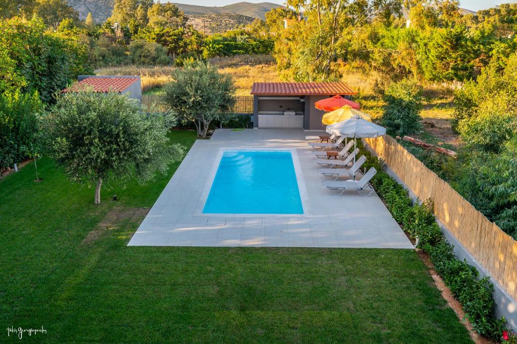 a swimming pool with lounge chairs and an umbrella at Apartment inside Villa Daniela-Elegant & Luxury Style-Private Pool in Schinias