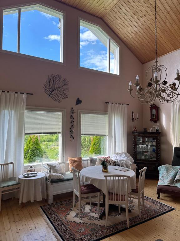 un soggiorno con tavolo, sedie e finestre di Villa Paalasmaa a Paalasmaa