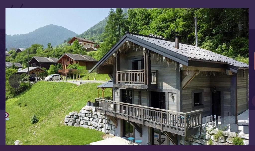 une maison avec balcon sur une colline dans l'établissement Chalet du Bonheur, à Bonnevaux