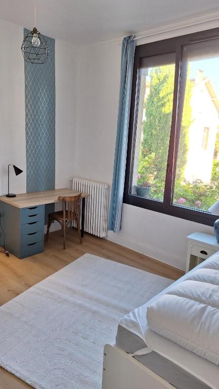 une chambre avec un lit, un bureau et une fenêtre dans l'établissement Appartement 2 chambres entièrement meublé et refait à neuf, à Toulouse