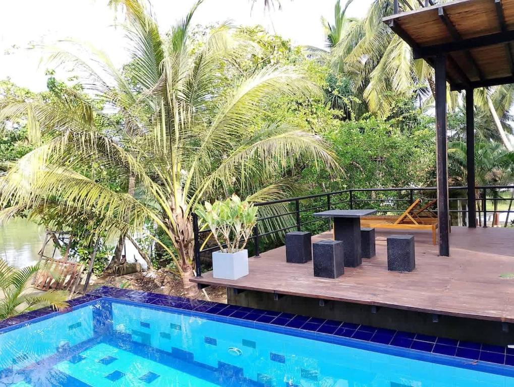 a resort with a pool and a table and a palm tree at Ko Lake Villa in Ahangama