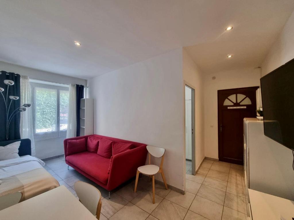 - un salon avec un canapé rouge et un lit dans l'établissement Monaco CARNIER Parking, à Beausoleil