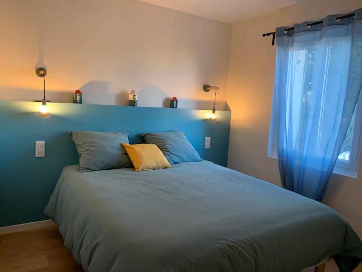 - une chambre avec un lit bleu et une tête de lit bleue dans l'établissement Le Narvick proche port-clim-wifi-parking, à La Ciotat