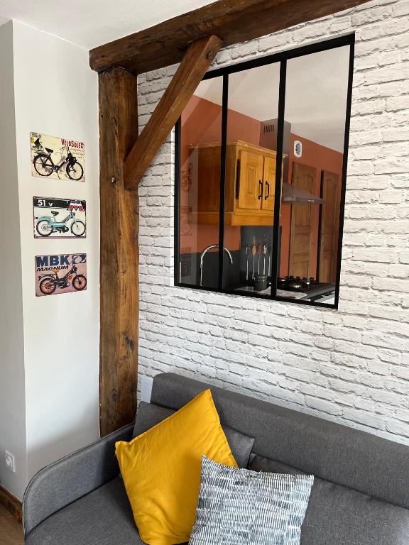 un salon avec un canapé et une fenêtre dans l'établissement La Petite Reine de l'Abbaye, à Thiers