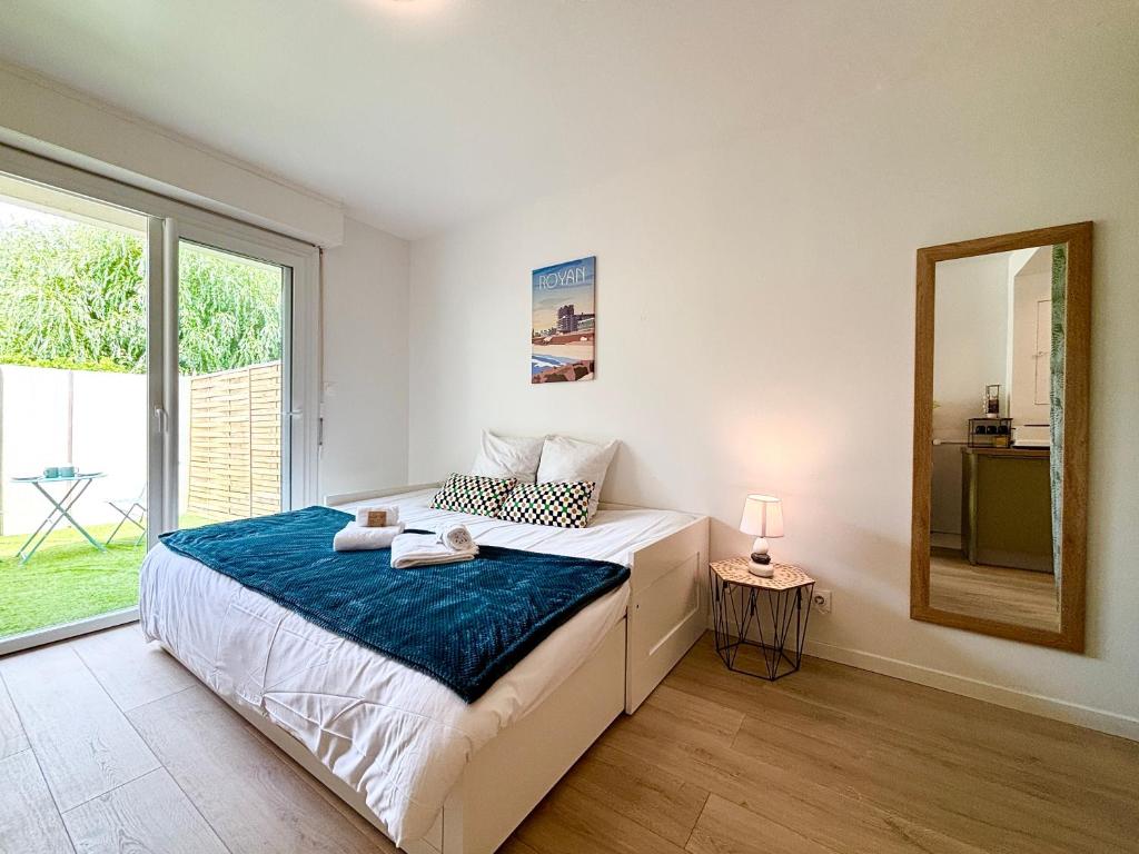 une chambre avec un lit et une grande fenêtre dans l'établissement Le Cordouan, Terrasse Extérieure, Royan, à Royan