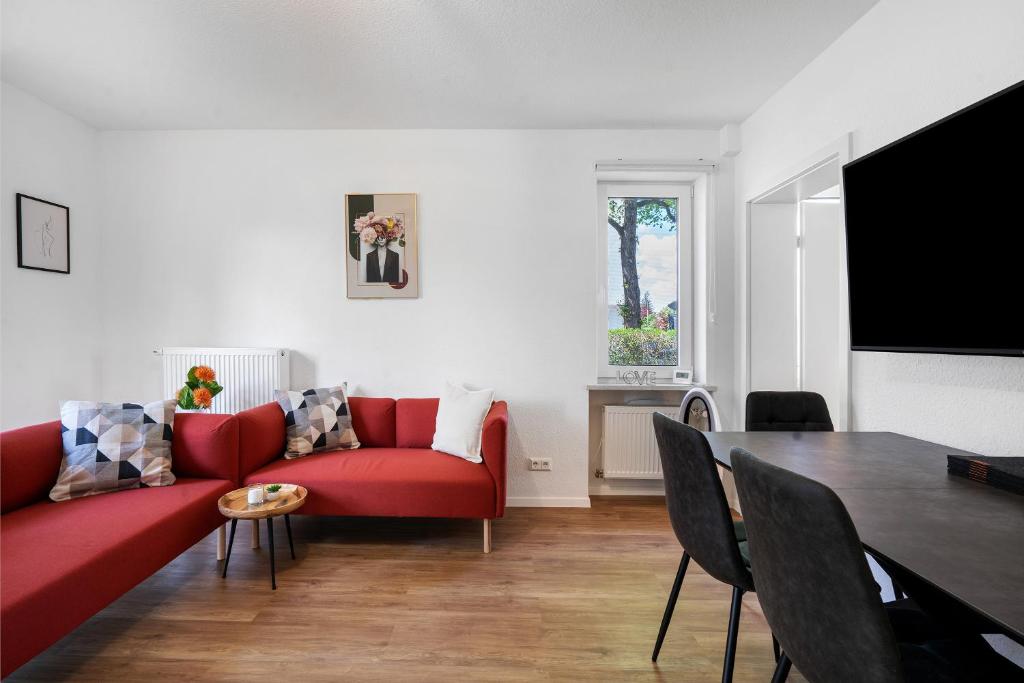 Una sala de estar con un sofá rojo y una mesa. en Ferienwohnung in München Eg, en Múnich