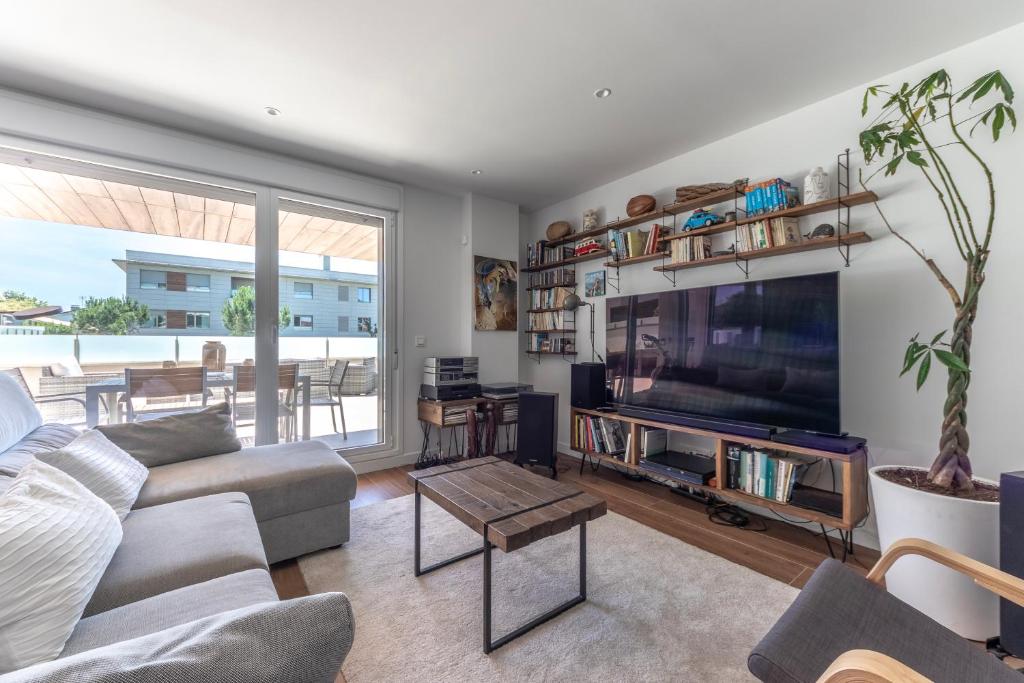 a living room with a couch and a tv at Aston - Sopela relajante cerca de la playa in Bareño