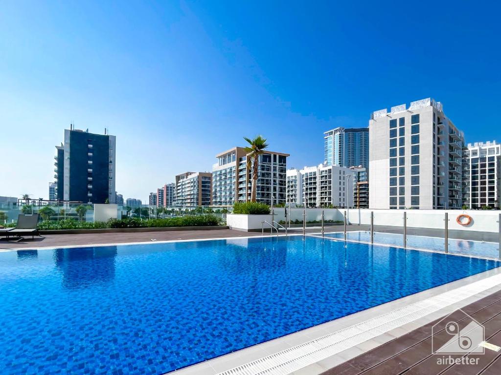 ドバイにあるChic 1BR Apartment with Pool View in Medyanの高層ビルが立ち並ぶ都市にある大きなプール