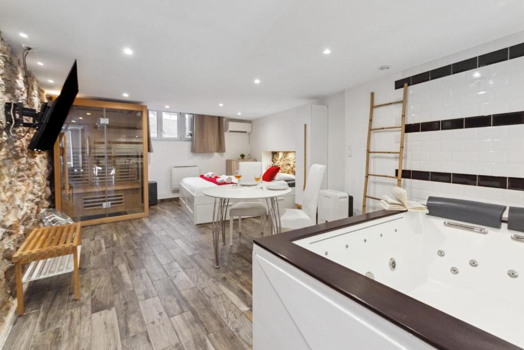 a kitchen and dining room with a tub and a table at La Suite Confidentielle - Balneo - Sauna - Hypercentre in Cannes