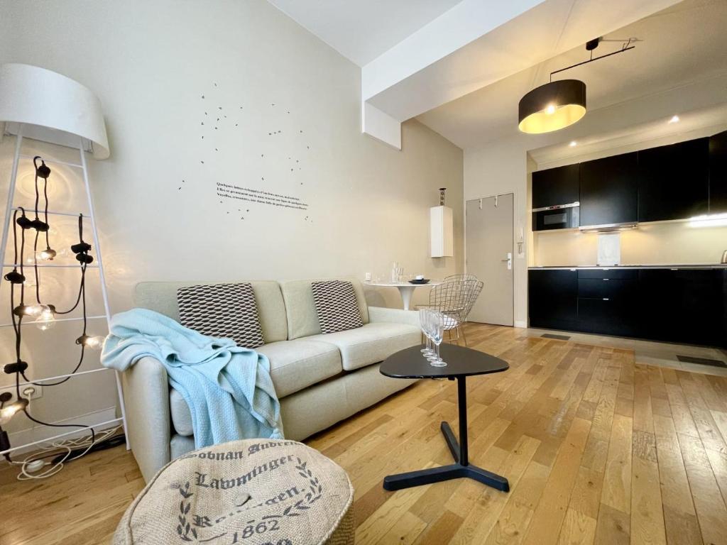 un salon avec un canapé et une table dans l'établissement PARISIAN HOME l BELLAN, à Paris