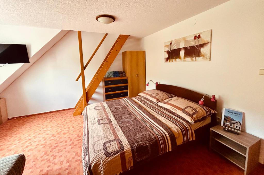 Un dormitorio con una cama y una escalera. en Apartmama Lipová, en Lipová-lázně