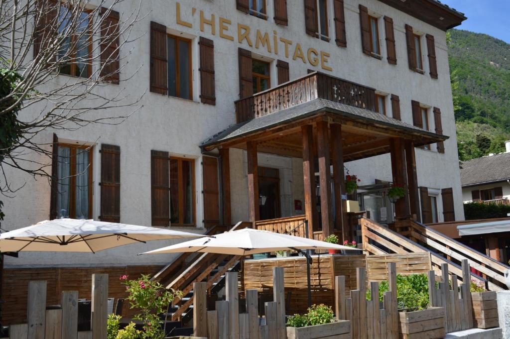 un hôtel avec des parasols devant un bâtiment dans l'établissement Hôtel l'Hermitage, à Brides-les-Bains