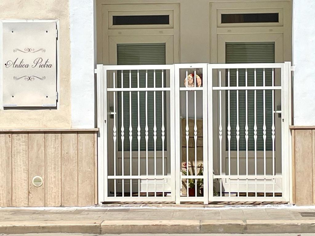 a white gate in front of a house at Antica Pietra in Polignano a Mare
