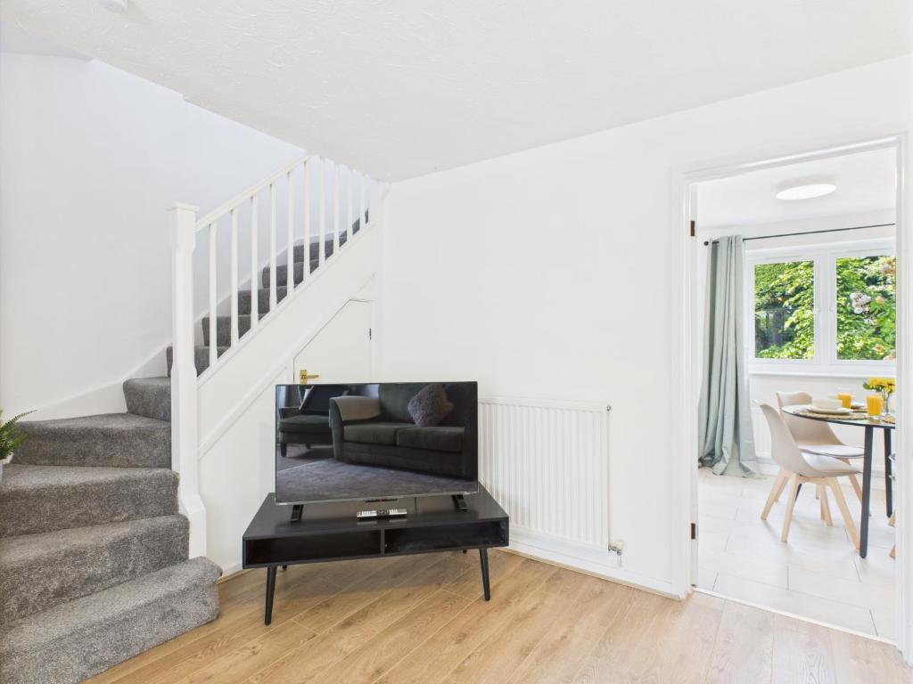 a living room with stairs and a table at Bright & Modern Stay in Central Wolverhampton I Free Parking in Fallings Park