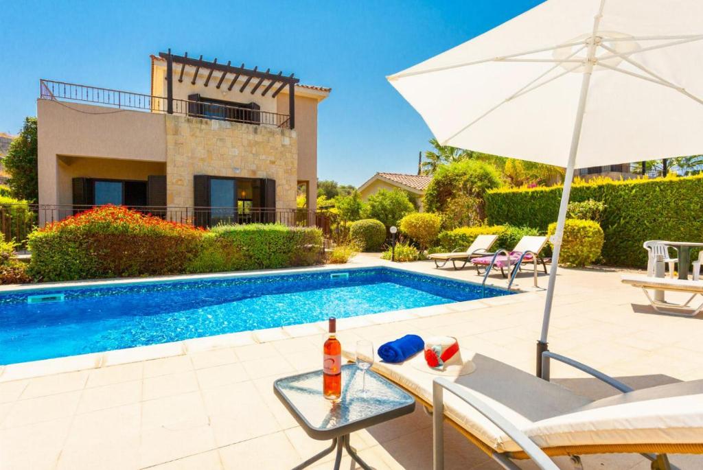 una villa con piscina y sombrilla en Villa Fortuna, en Polis Chrysochous