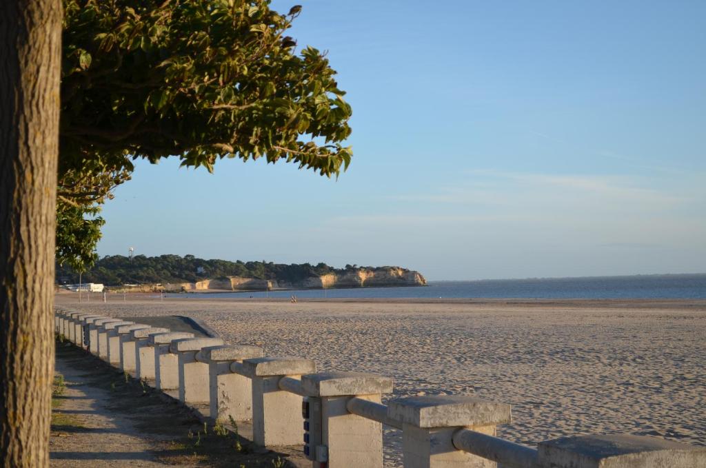 une plage avec une clôture et un arbre dessus dans l'établissement Le Gravelot Royannais, à Royan