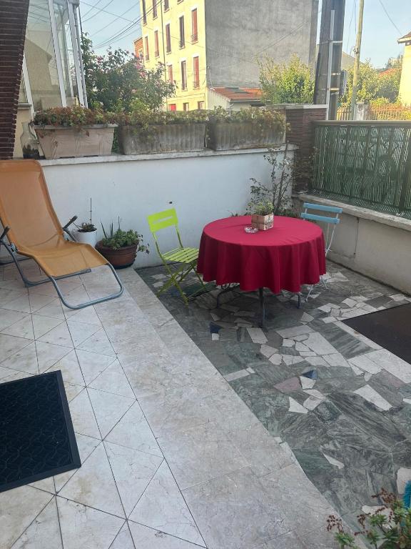 d'une terrasse avec une table rouge et deux chaises. dans l'établissement Warm and fully equipped studio, à Aubervilliers