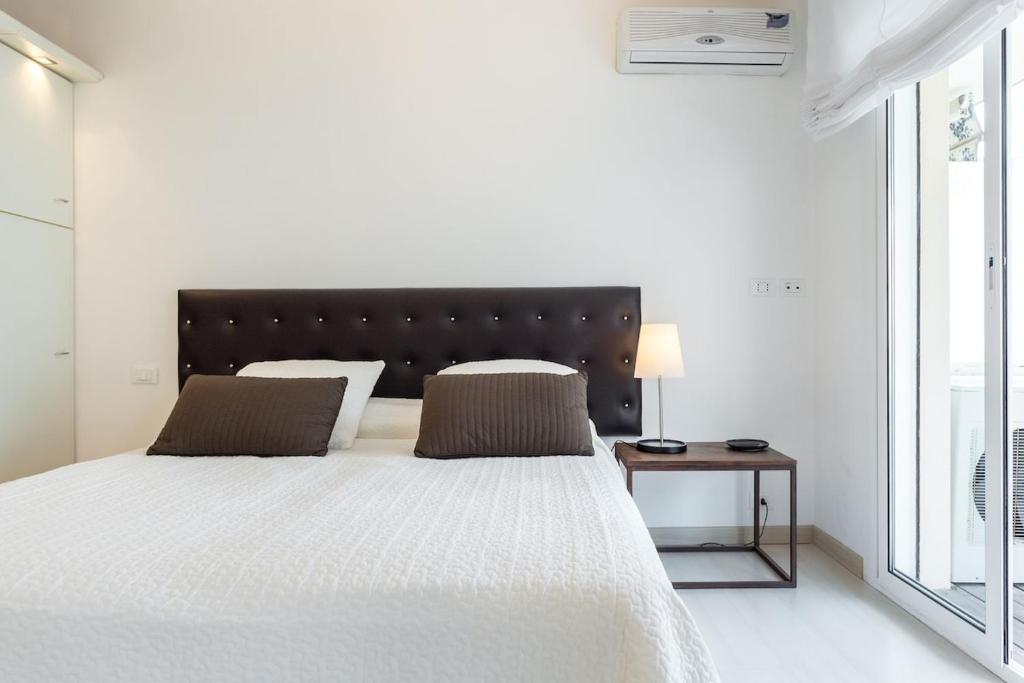 une chambre blanche avec un grand lit et une fenêtre dans l'établissement Charming & Elegant La Croisette apartment in Cannes, à Cannes