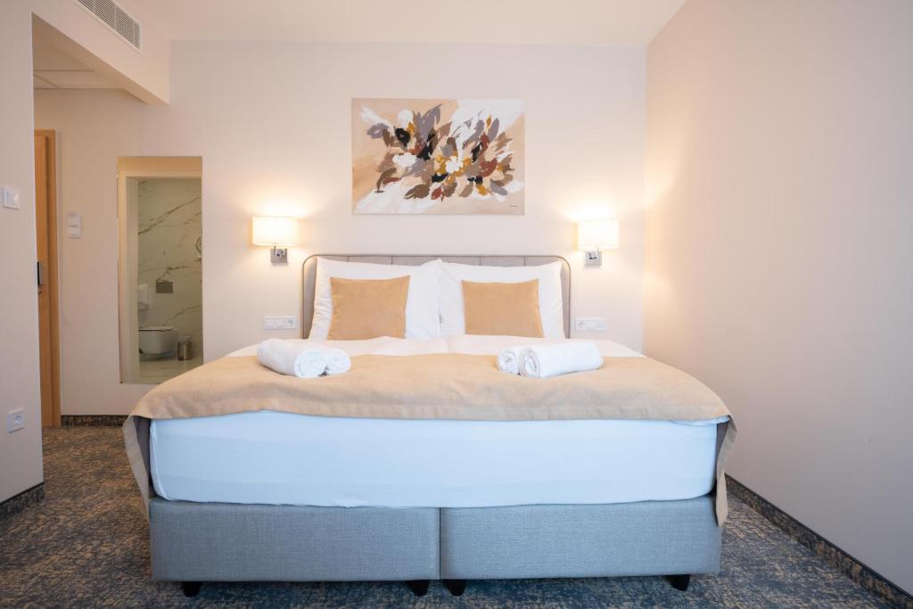 Postel nebo postele na pokoji v ubytování Kikelet Club Hotel