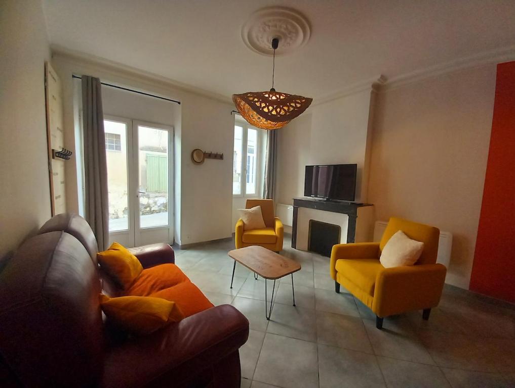 - un salon avec un canapé, des chaises et une cheminée dans l'établissement Maison de ville 3 chambres climatisées, à Bourg-Saint-Andéol