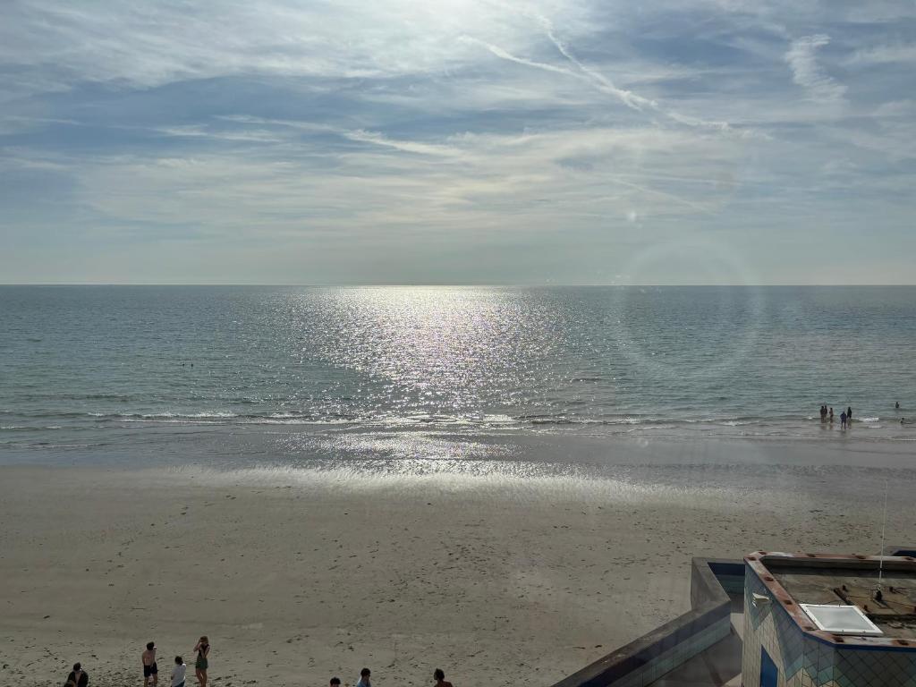 un groupe de personnes marchant sur la plage dans l'établissement T h e - P L A I C E, à Wimereux